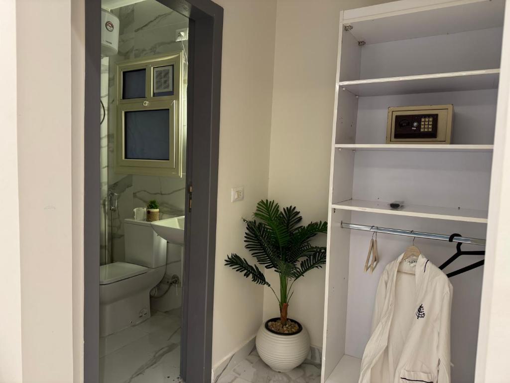 a bathroom with a toilet and a plant in it at Colour holiday Zayed in Sheikh Zayed