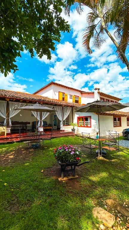 a house with a planter of flowers in the yard at POUSADA PARLATORIUM in Tiradentes