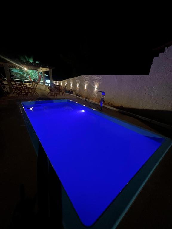 a blue swimming pool at night with lights at Casa brisa do mar icapuí in Icapuí