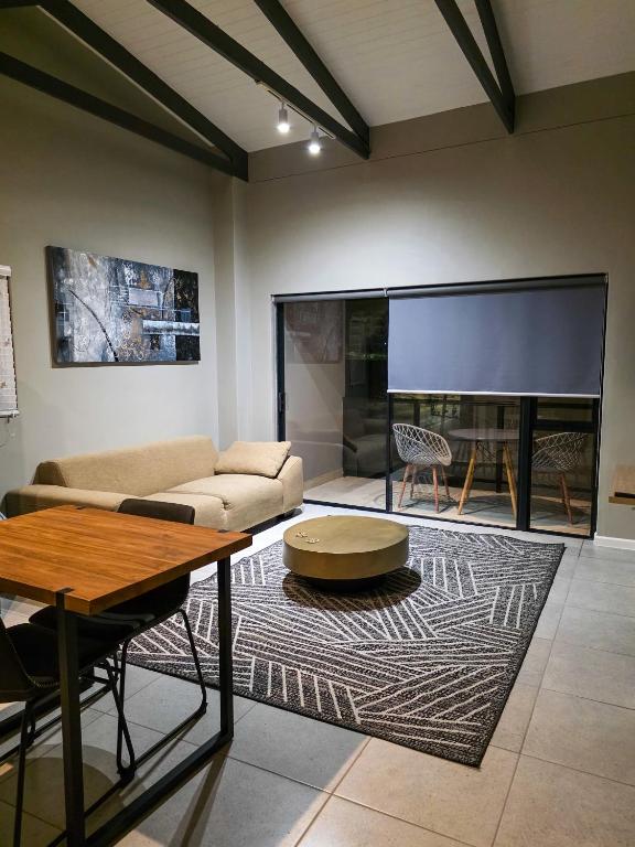 a living room with a couch and a table and a tv at West Coast Apartment 85 in Langebaan