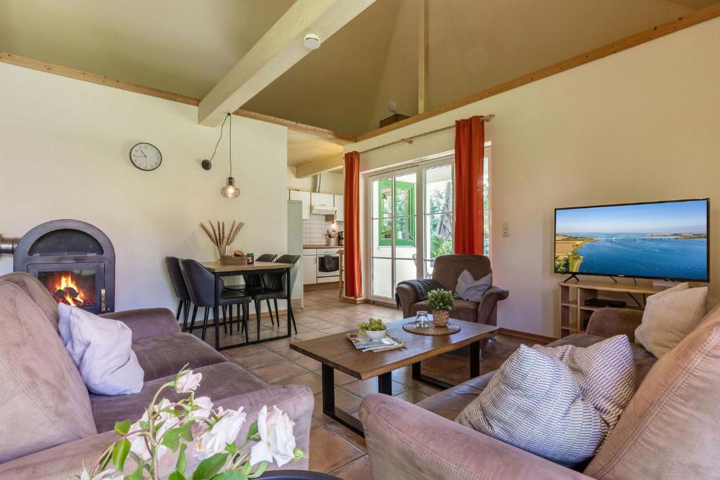 a living room with a couch and a tv at Ferienhaus 4 in Fehmarn