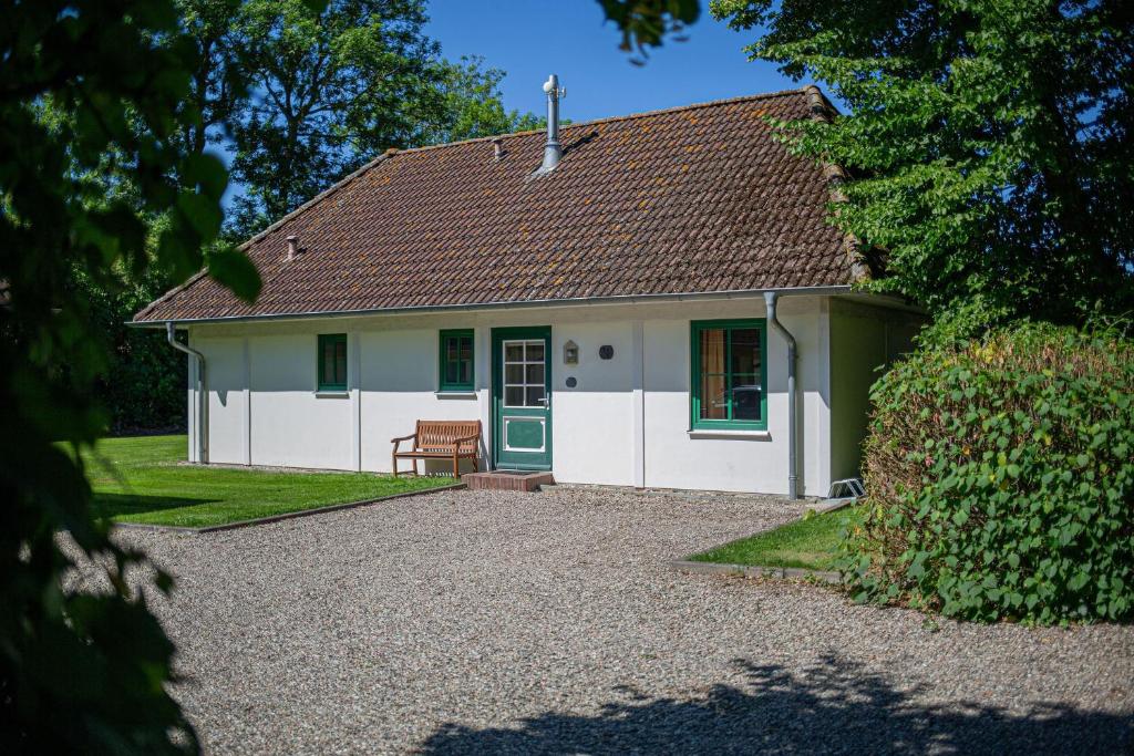 a white house with a bench in front of it at Ferienhaus 2 in Fehmarn
