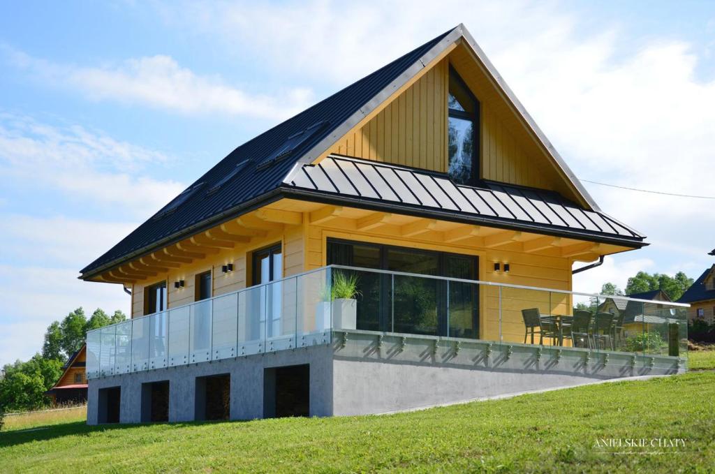 a house with a metal roof on a hill at Anielskie chaty - domki z widokiem na góry in Sablówka