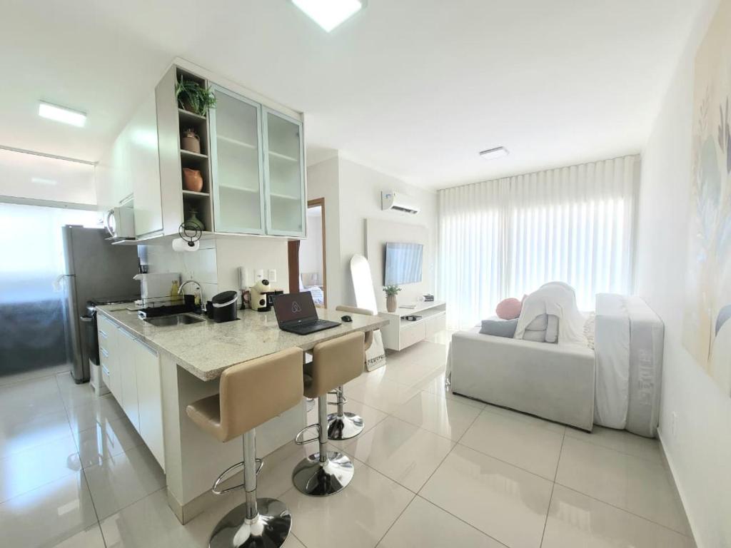 a kitchen and living room with a laptop on a counter at GALILEU - Apartamento próximo à UniCPO, Mondelli, USP, FACOP e FIASP in Bauru