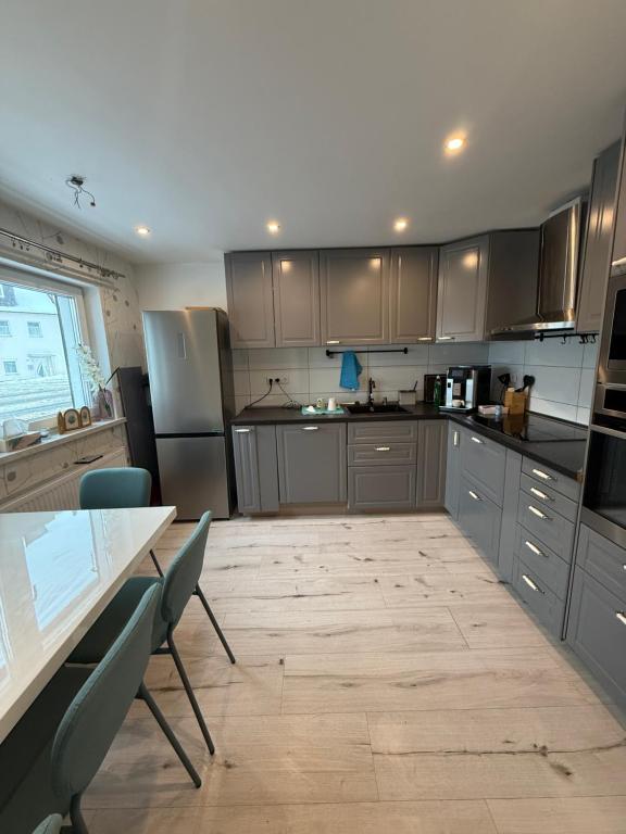 a kitchen with gray cabinets and a table and chairs at Schelder Zimmer in Dillenburg