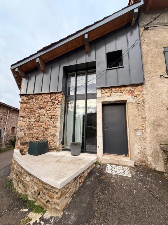 a house with a large window on the side of it at La P'tite Bicoque in Doizieux