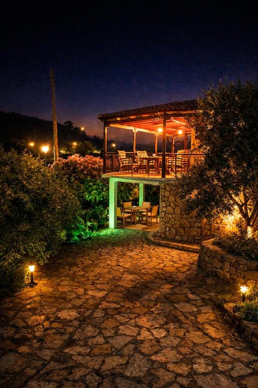 a house with a deck with lights on it at night at Alma-Maroon Klara & Rachel in Drymon