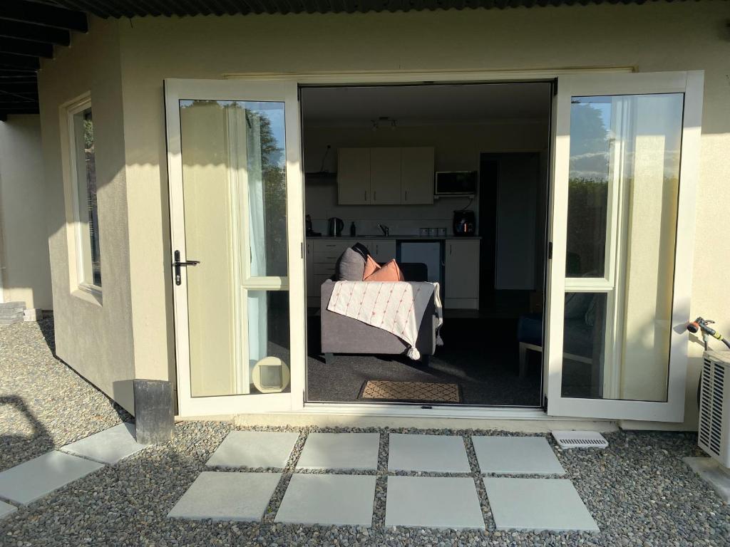 a person sitting in a couch outside a door at Property close to the beach in Nelson
