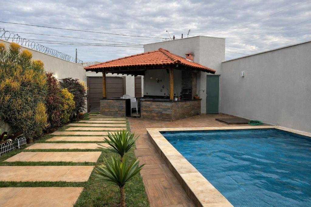 a house with a swimming pool in the yard at Pousada e Edícula in Jabuticabal