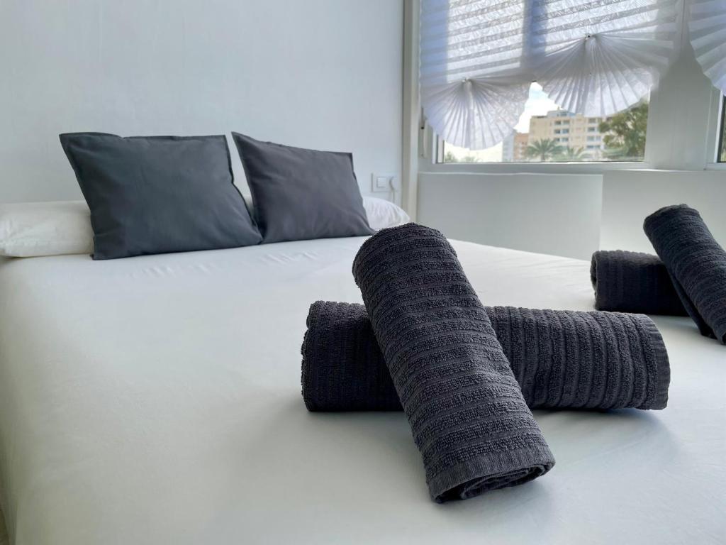 a bed with three gray pillows on it at Estudio Vista Mar & Piscina - 200 m de la playa in Aguadulce