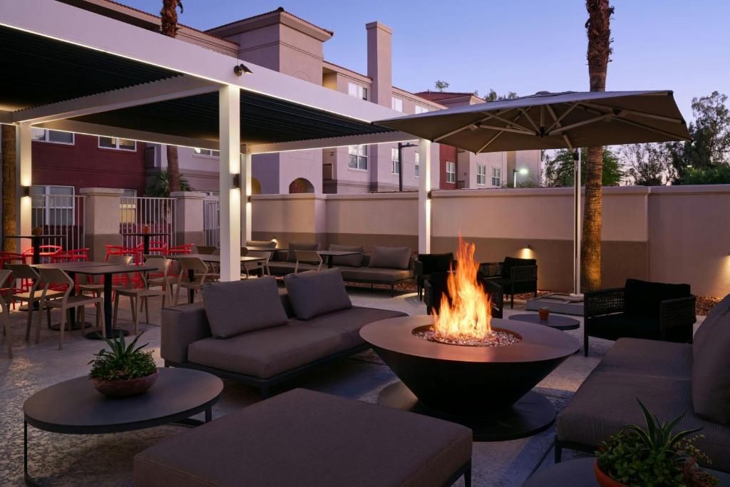 a patio with a fire pit with couches and tables at Residence Inn Phoenix Mesa in Mesa