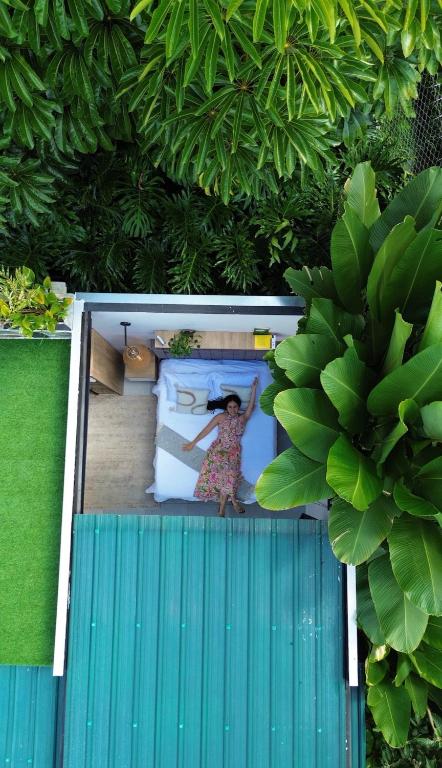 a woman is sitting on a bed in a room at Cielo Abierto Cabaña Glamping in Quimbaya