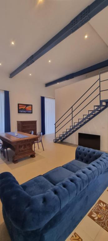 a living room with a blue couch and a ping pong table at La Dimora del Cardinale in Naples