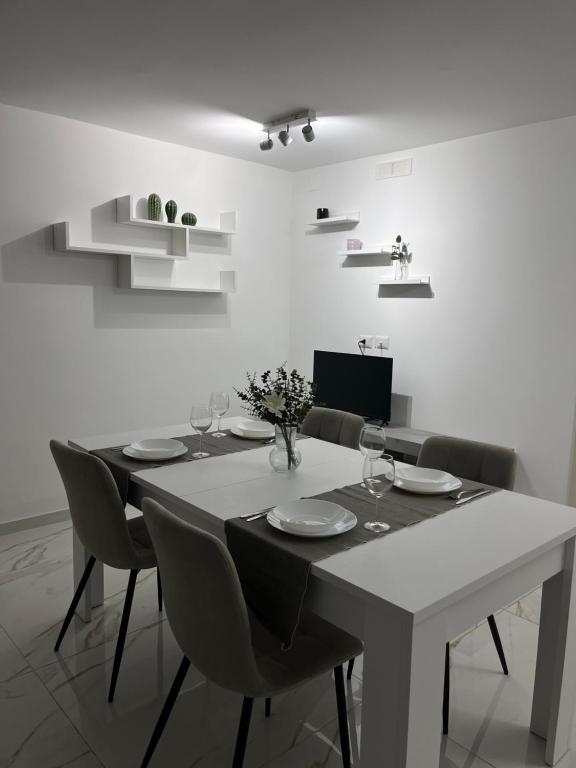 a white dining room with a table and chairs at Casa del maresciallo in Giovinazzo