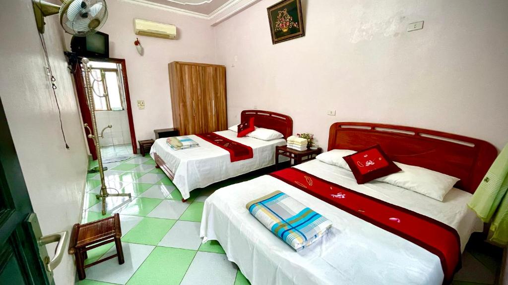 a hotel room with two beds and a bathroom at Xuân Thành Homestay in Vũ Lâm