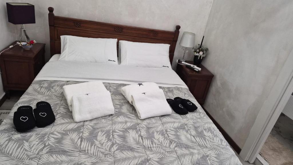 a bed with two pairs of shoes sitting on it at Dimora ANETT B&B HOUSE in Codevigo