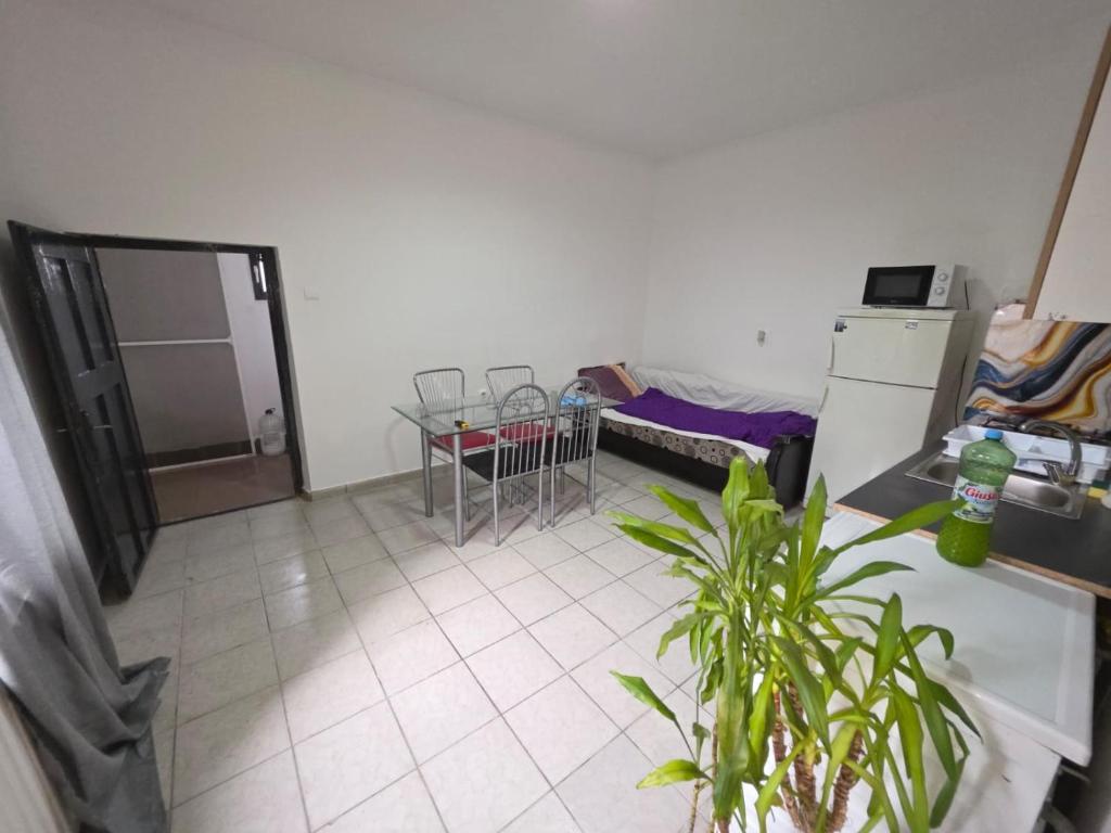 a room with a table and a kitchen with a bed at Matei Apartament in Tîrnăveni