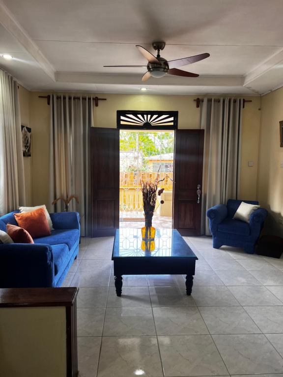 a living room with a blue couch and a table at Pinewood in Ocho Rios
