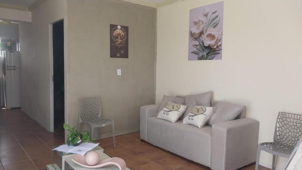 a white living room with a couch and a table at Flat vista mar in Paulista