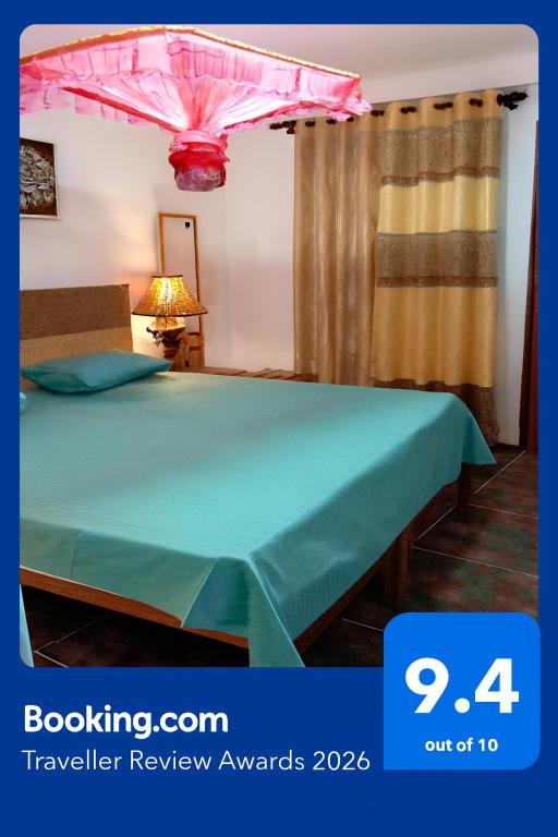 a bedroom with a green bed with a pink umbrella at Princess Villa Kandy Rail Station in Kandy