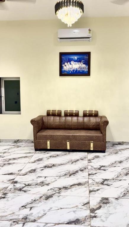 a brown couch in a white room with a chandelier at Aarambh Villa in Sātirje