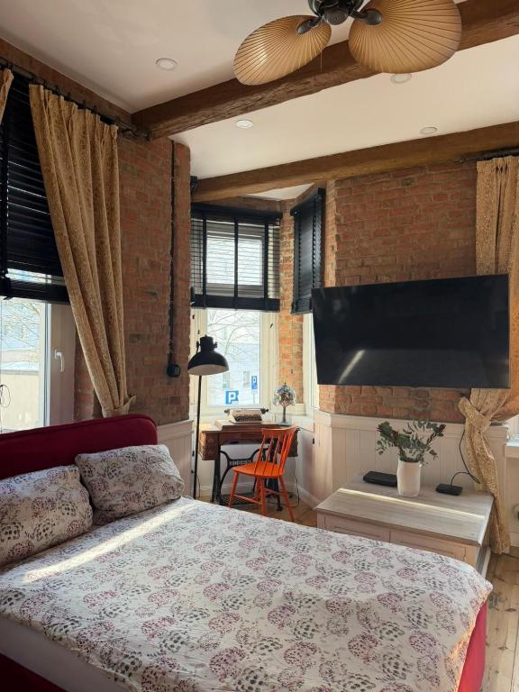 a bedroom with a bed and a flat screen tv at Apartments PSD - Filmowa in Słupsk