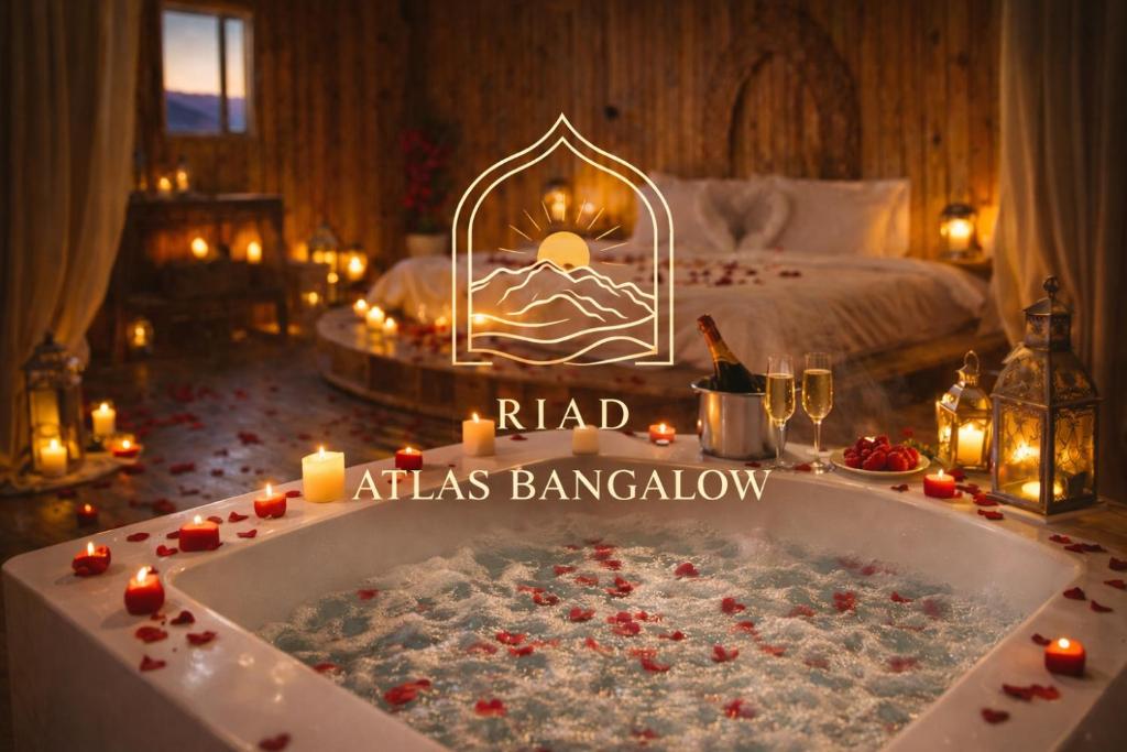 a room with a bath tub with candles and a bed at Riad Atlas Bangalow in Imlil