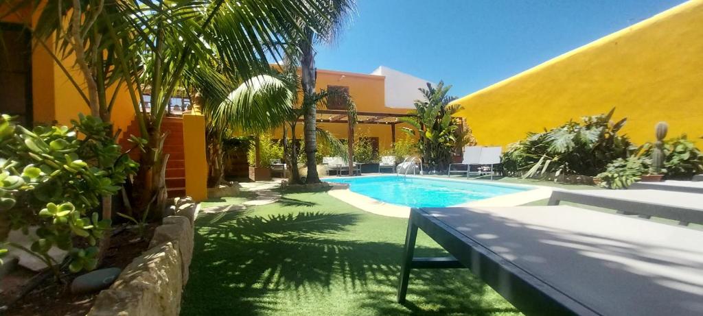 a swimming pool in front of a building with a yellow at Casa Mestre Guesthouse in Vila do Bispo