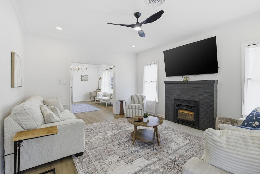 a living room with a couch and a fireplace at The Lake Charles Charmer in Lake Charles