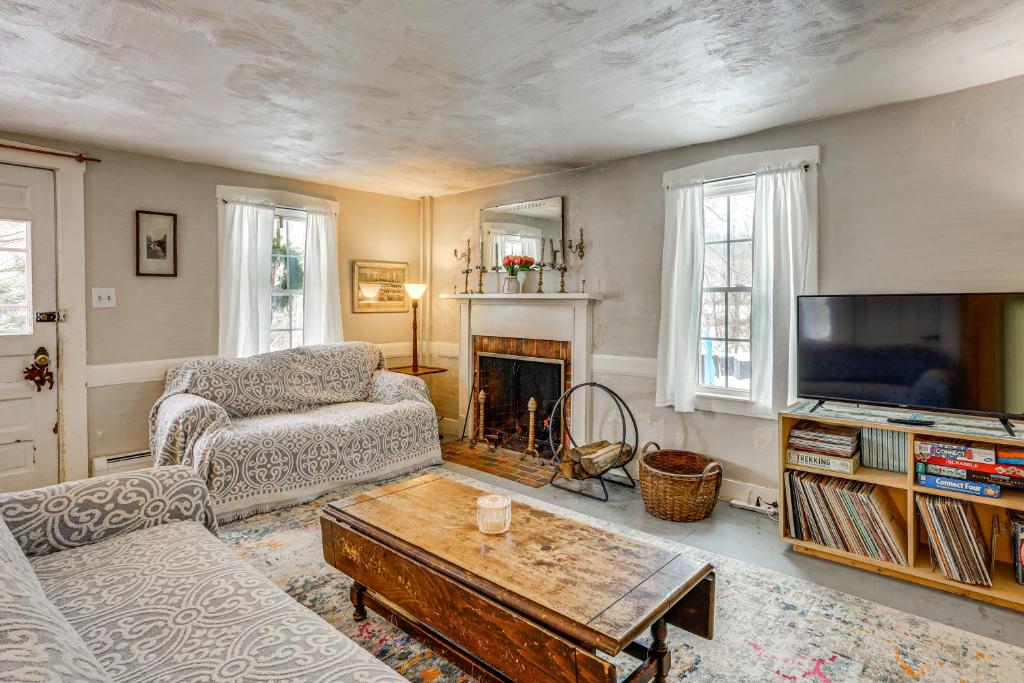 a living room with a couch a coffee table and a tv at Historic 1820s Homestead on Battenkill River! in Arlington