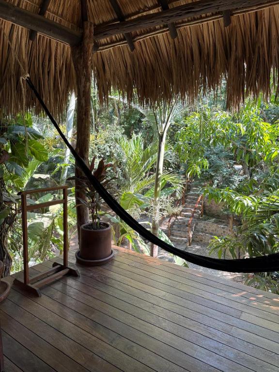 a hammock on the deck of a thatch hut at Loft Amplio con Vista Natural en Mazunte in Mazunte