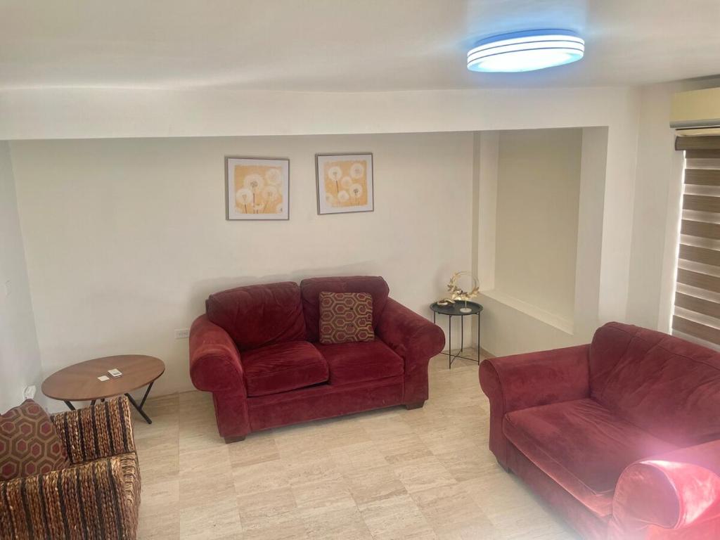 a living room with a red couch and a chair at Casa 5 Centrica Super ubicada 3 camas queen in Hermosillo