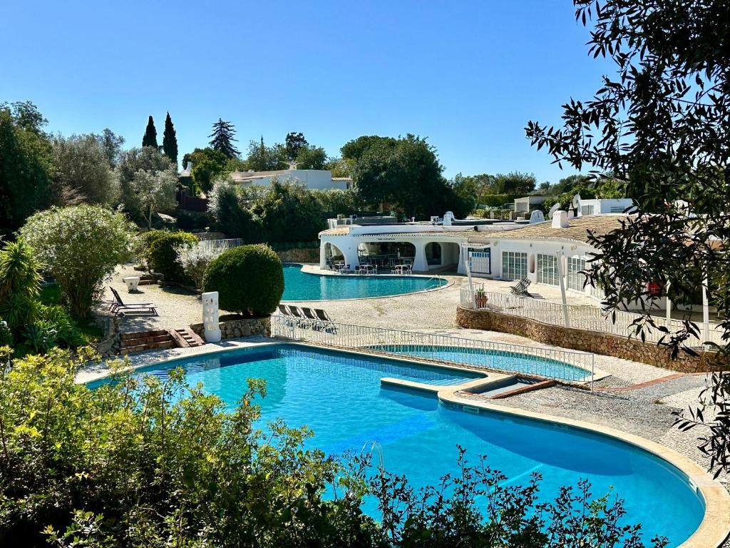 two swimming pools with blue water in a yard at Casa Luca in Carvoeiro