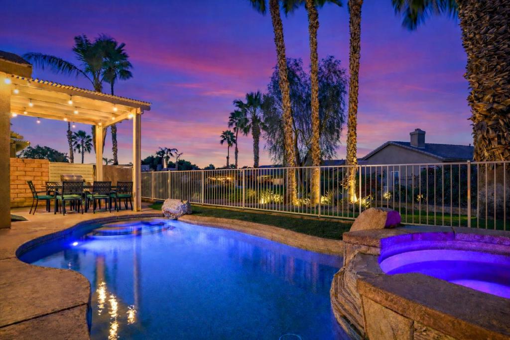 a swimming pool in a backyard with a fence at Indio Access Vacation Home in Indio