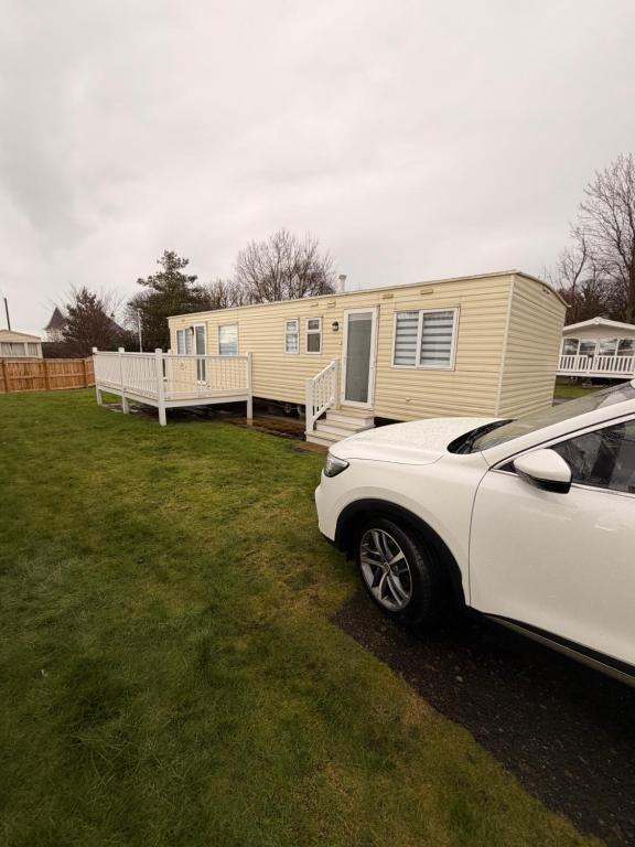 a white car parked in front of a mobile home at Hoopers Hideaway Caravan Rental SetonSands 2 in Port Seton