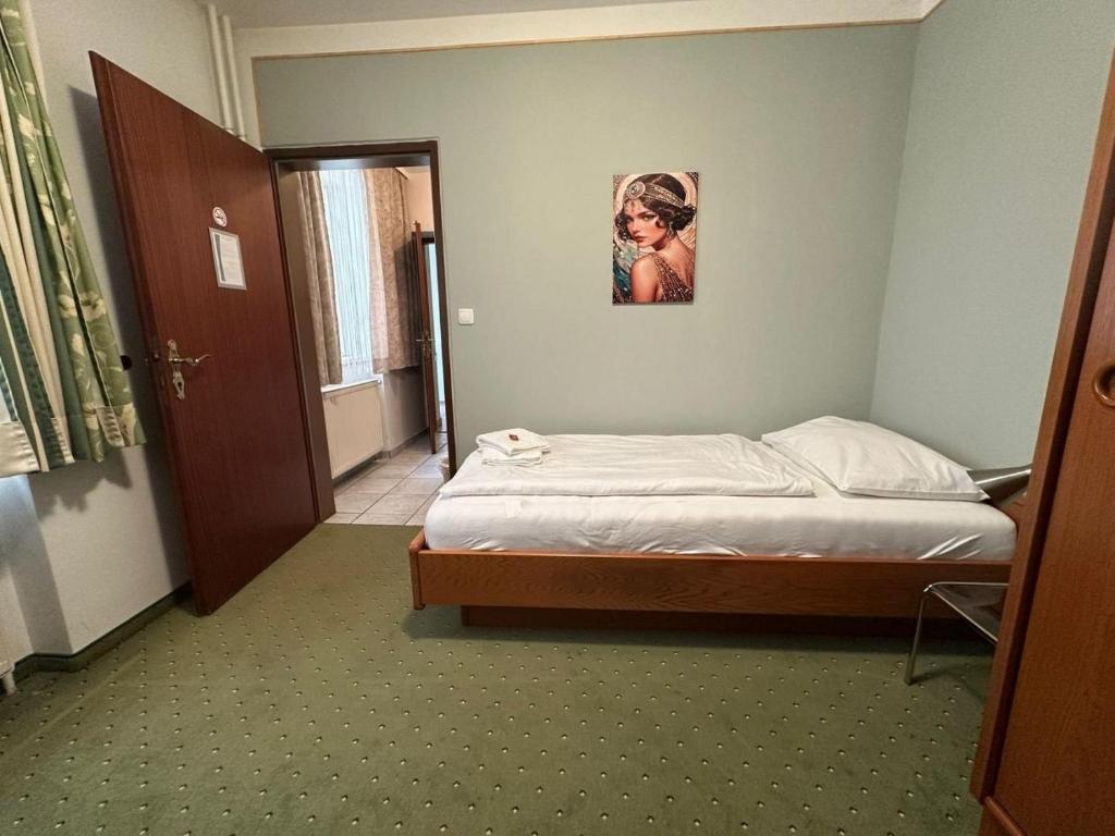 a small bedroom with a bed and a door at Mariazellerhof Room 014 in Sankt Pölten