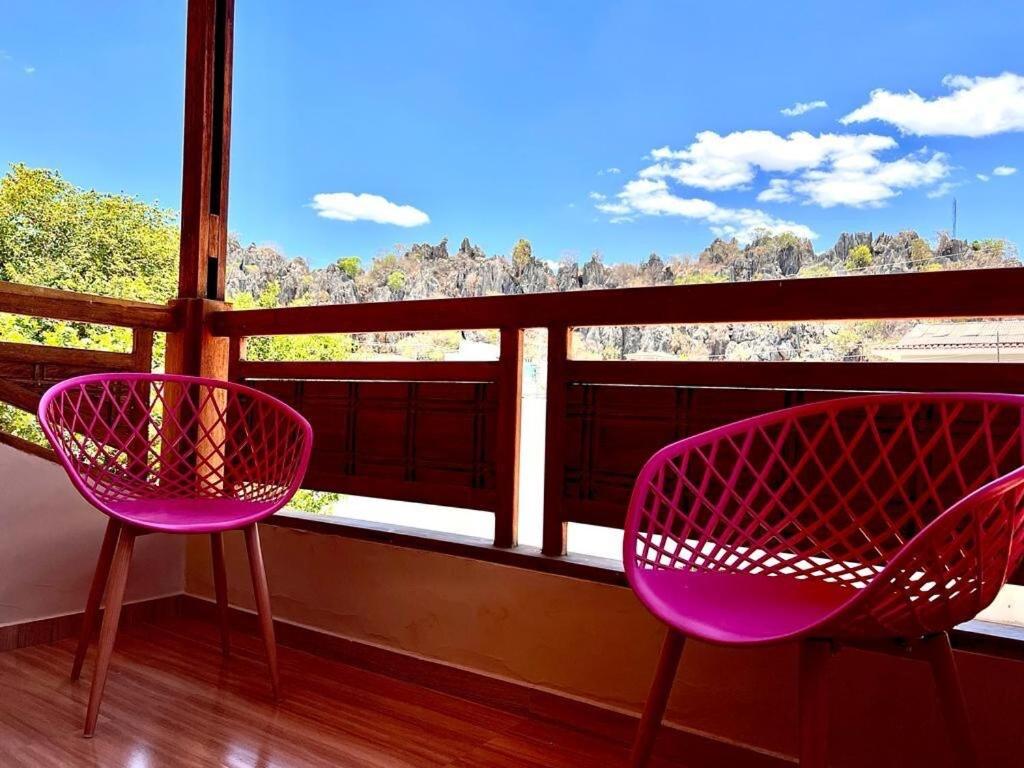 two pink chairs sitting in front of a window at Casa - Conceito in Bom Jesus da Lapa
