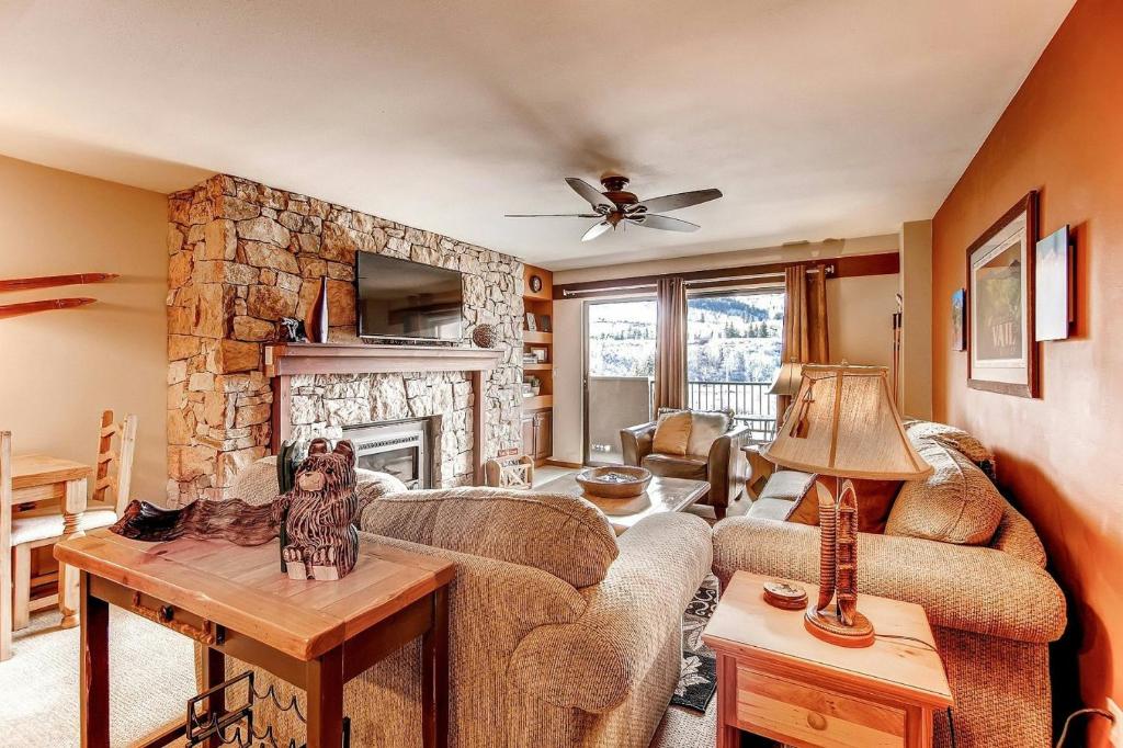 a living room with a couch and a stone fireplace at Seasons at Avon, A Vail Resorts Property in Avon