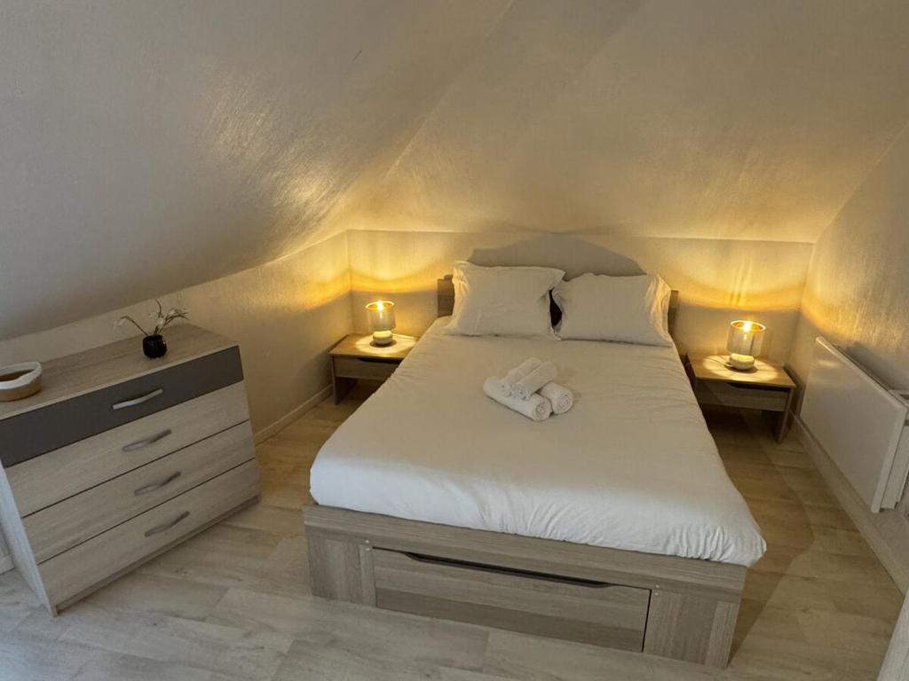 a bedroom with a bed with two lights on it at Appartement centre Compiègne in Compiègne