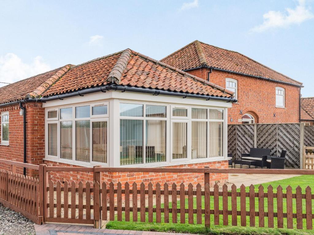 a detached house with a large conservatory with a fence at The Saddlery - Uk36123 in Horsington
