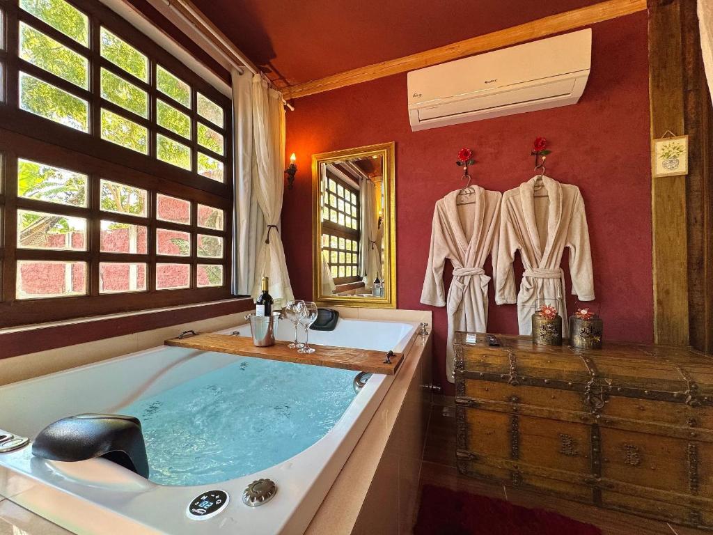 a bathroom with a large tub and a window at Divina Cabana - Lago Corumbá IV - Alexânia (GO) in Alexânia