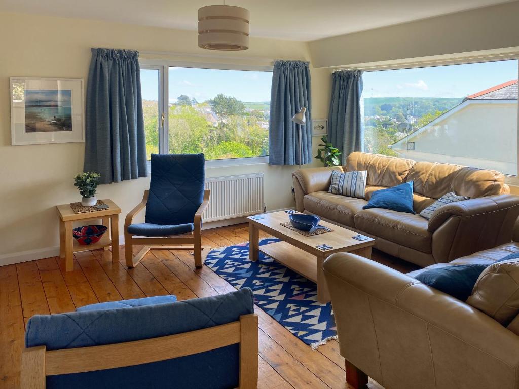 a living room with couches and chairs and a large window at Whitestones in Saint Mawes