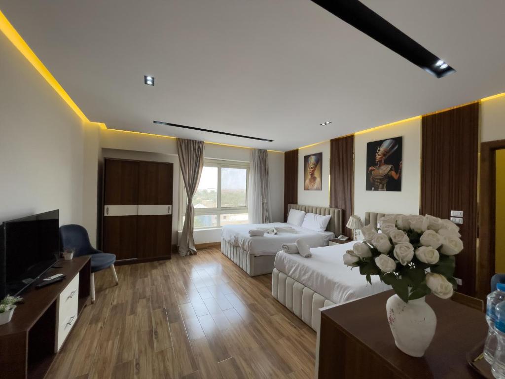 a large living room with a bed and a tv at Pyramids Sunshine View in Giza