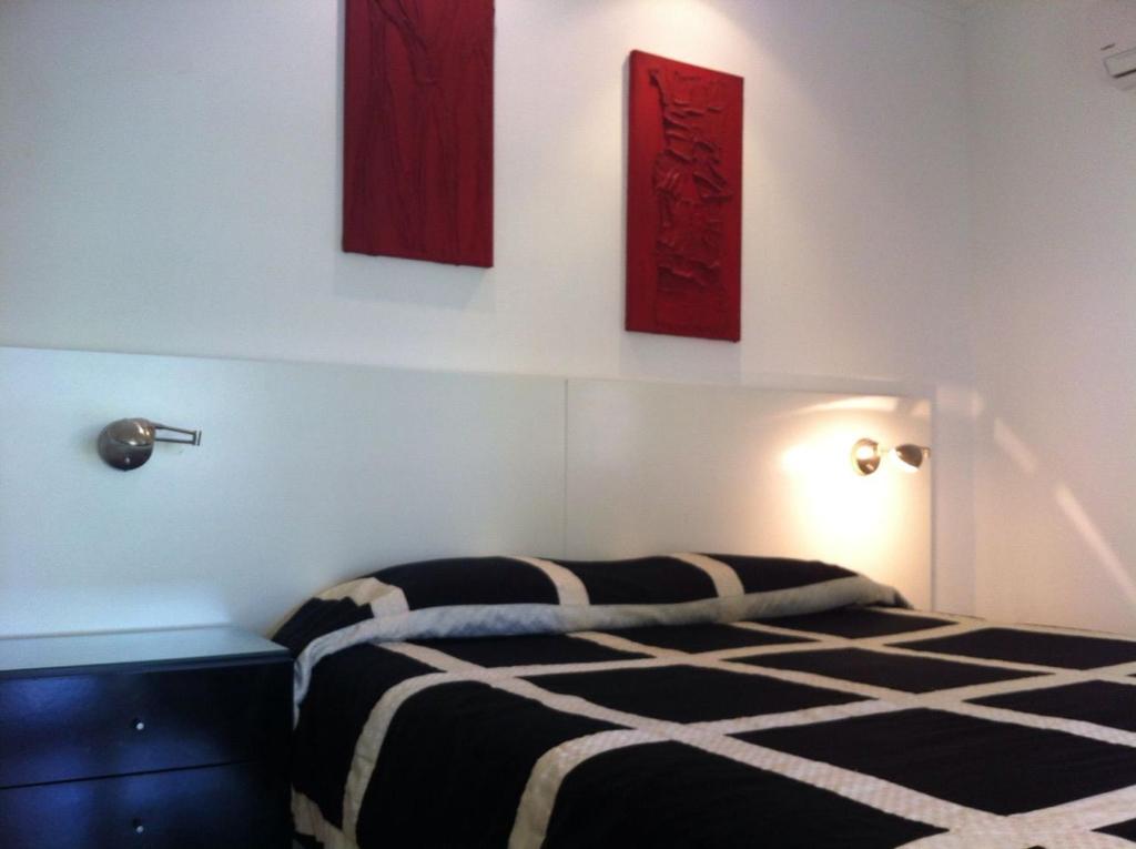 1 dormitorio con 1 cama y 3 cuadros en la pared en Departamento Green Park, en Punta del Este