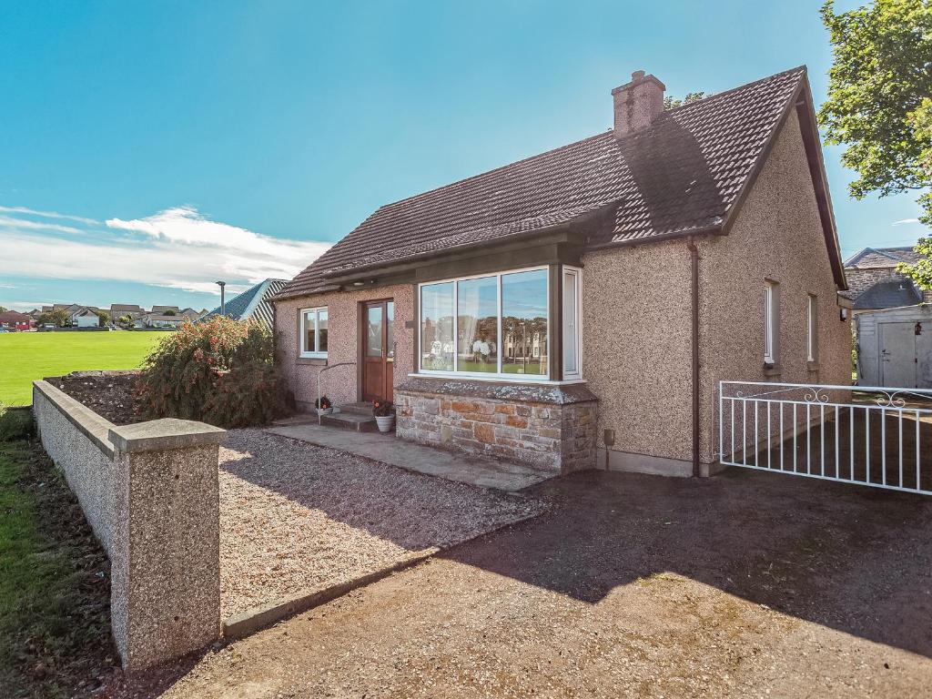 a brick house with a gate in front of it at Tanera in Wick