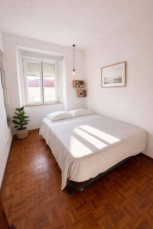 a bedroom with a large bed and a window at Sintra Central Apartment in Sintra