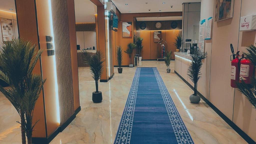 a hallway with a blue carpet in a building at ﻣﺆﺳﺴﺔ ﺷﻘﻖ ﺍﻟﻘﺎﺭﺍﺕ ﺍﻟﺴﺒﻊ ﺍﻟﻤﺨﺪﻭﻣﺔ in Raḩīmah