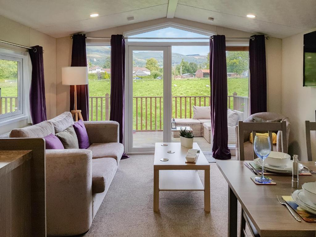 a living room with a couch and a table at Glenbeagles Lodge in Dollar