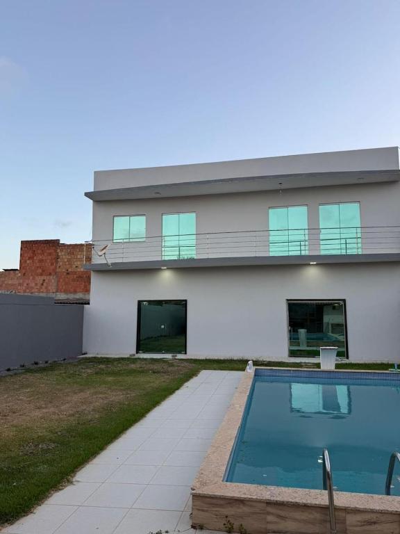 a house with a swimming pool in front of it at Casa Guriri in São Mateus