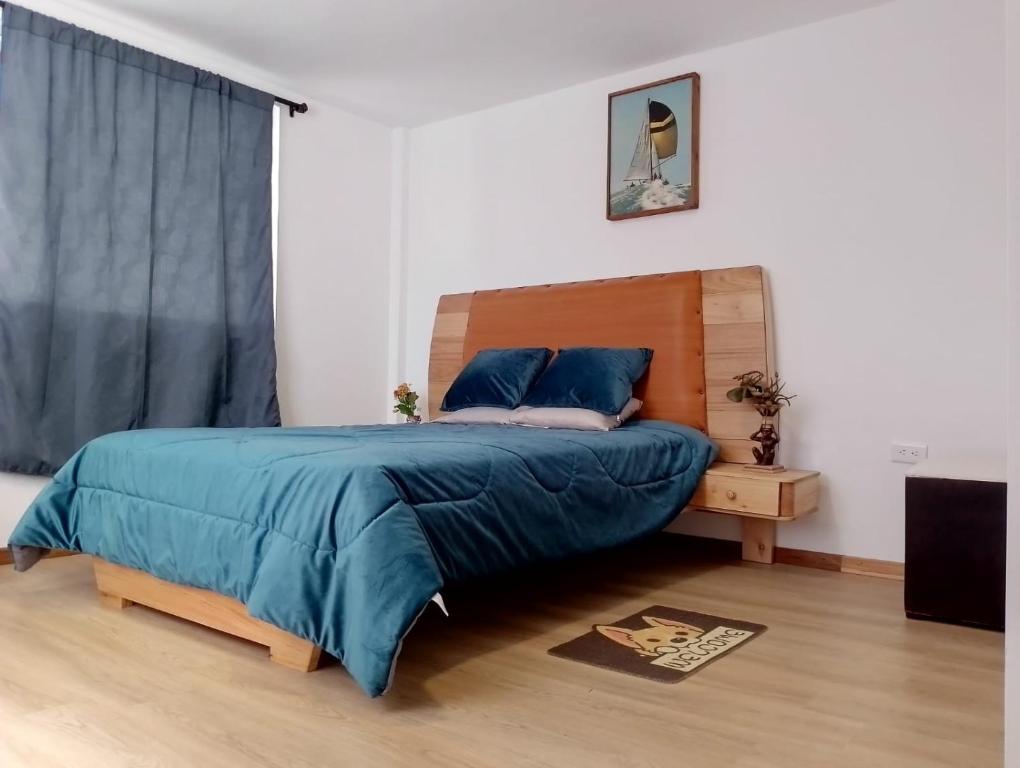 a bedroom with a bed with a blue comforter at Psi Nova in Baños